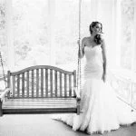 A bride next to a swinging chair on the porch