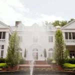 The front of Duke Mansion, with a fountain spraying water upward.